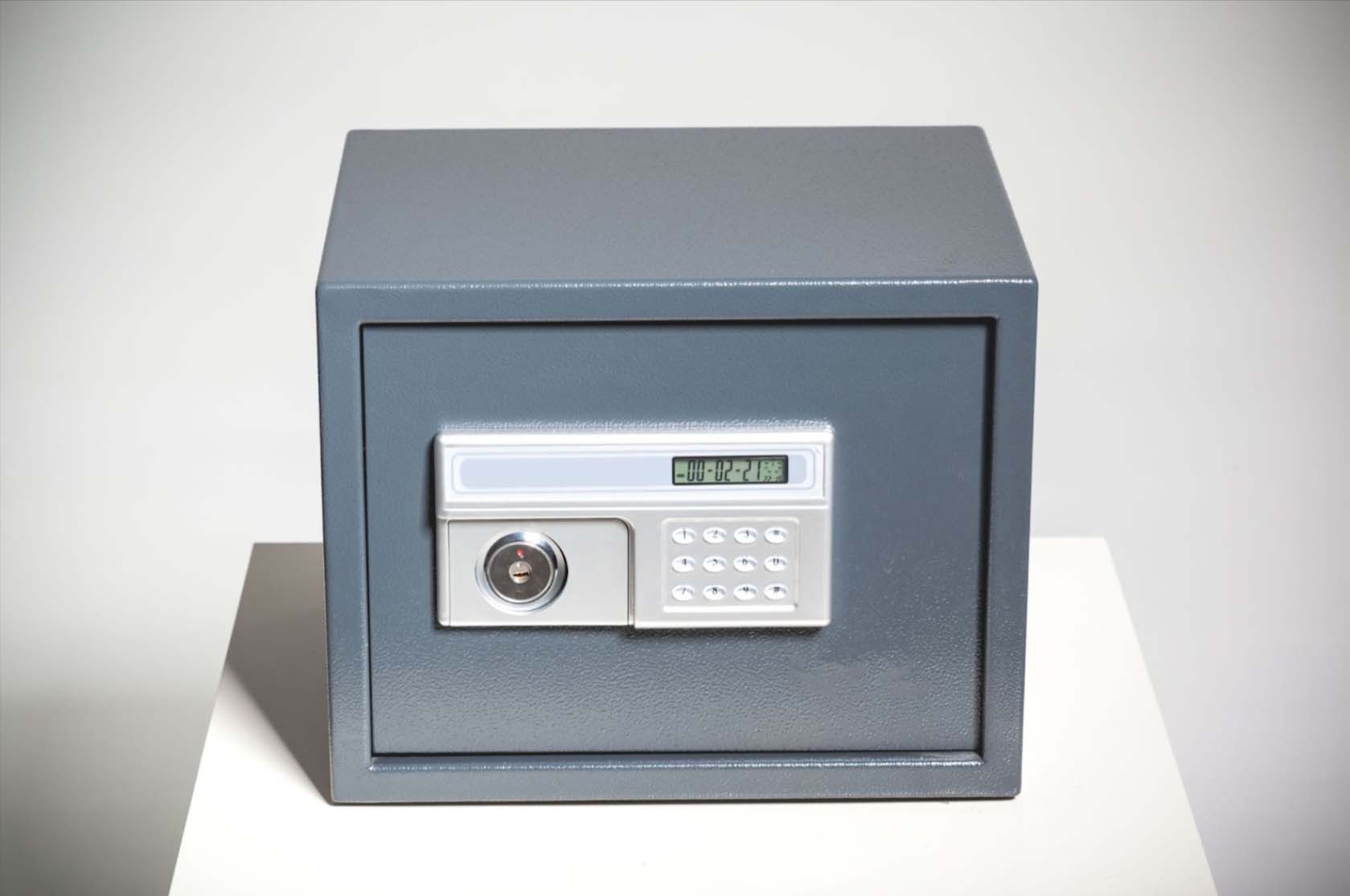 A closed safe sits against a gray background, securely guarding its contents.