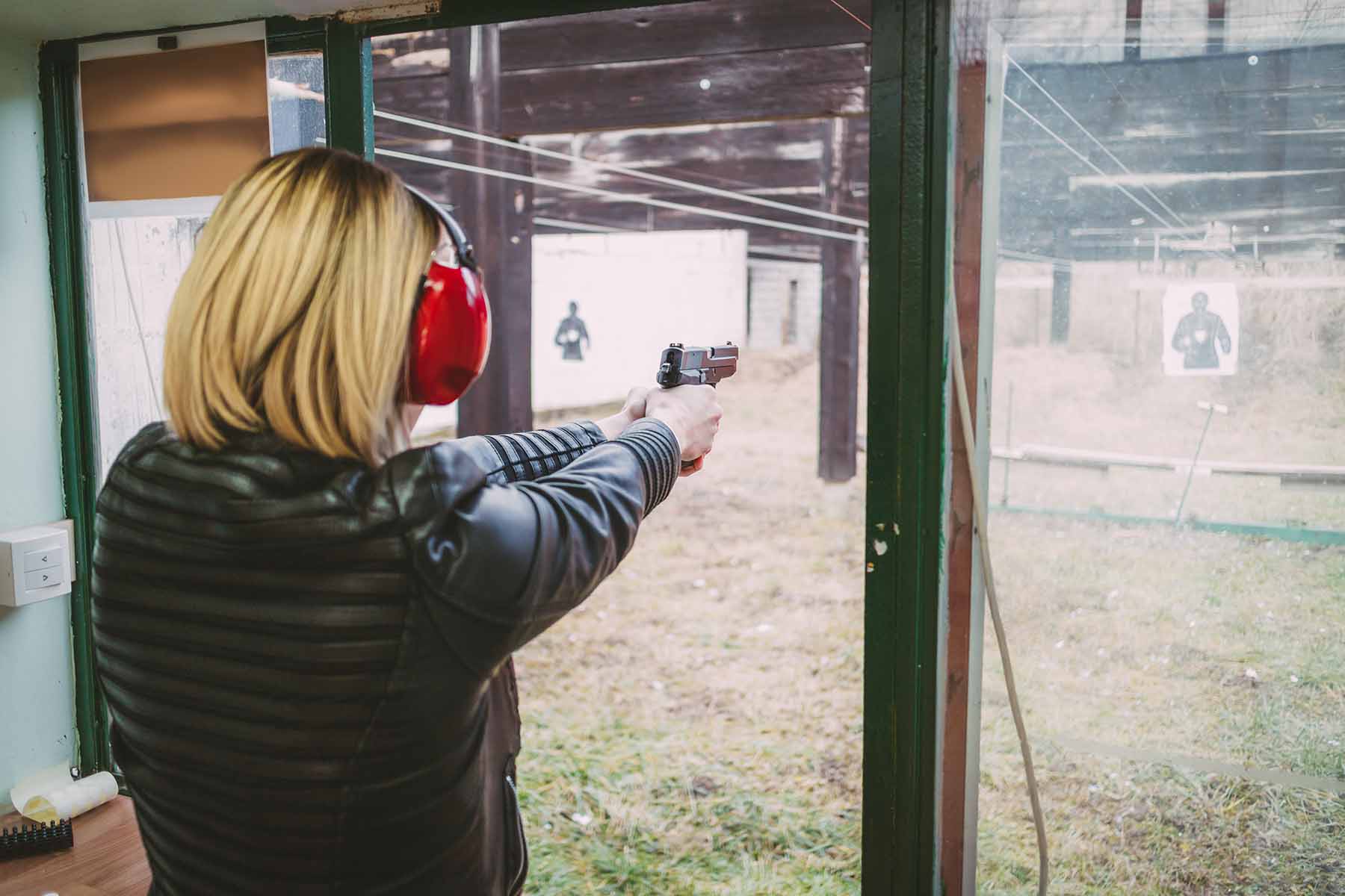 A woman concentrates on shooting the target.