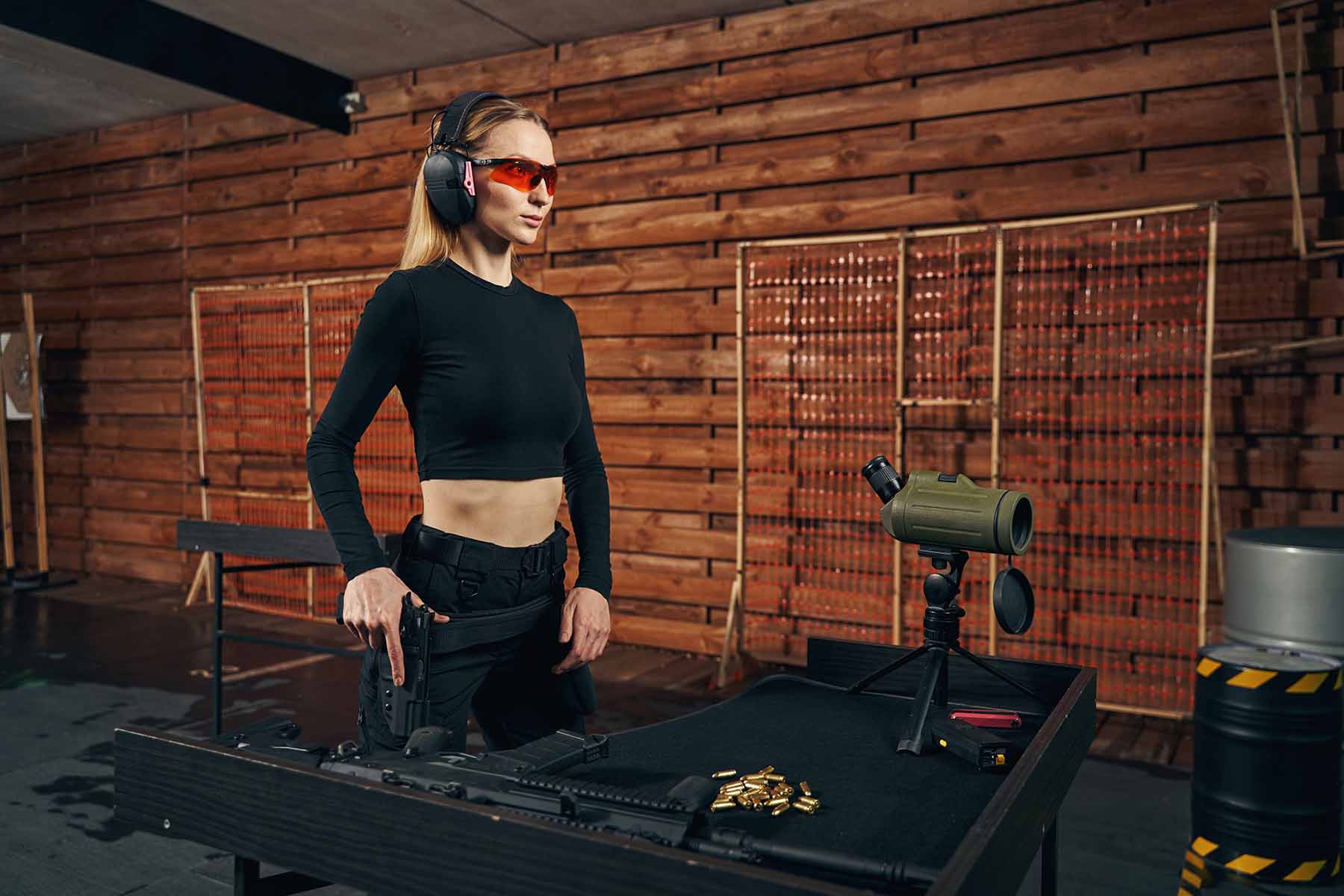 A woman is preparing herself before shooting targets at a shooting club.