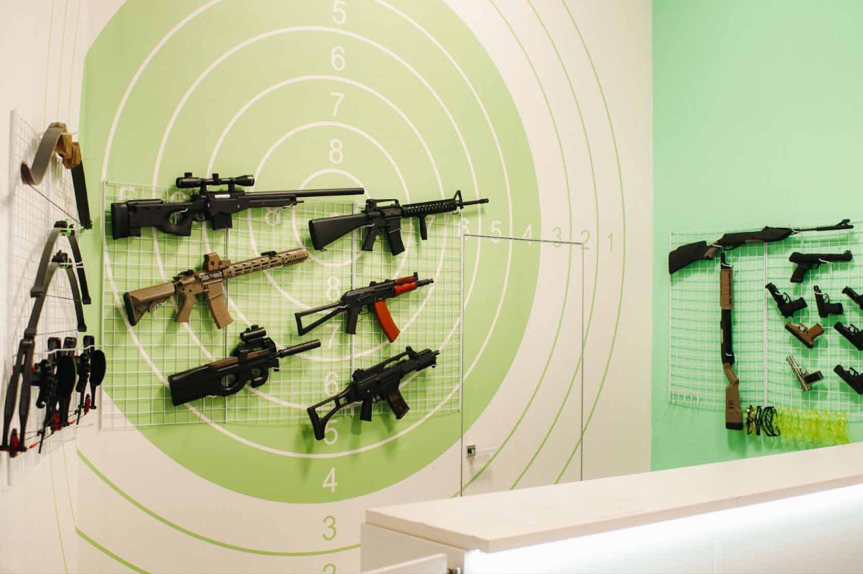 An assortment of sniper rifles and pistols showcased in a gun store.