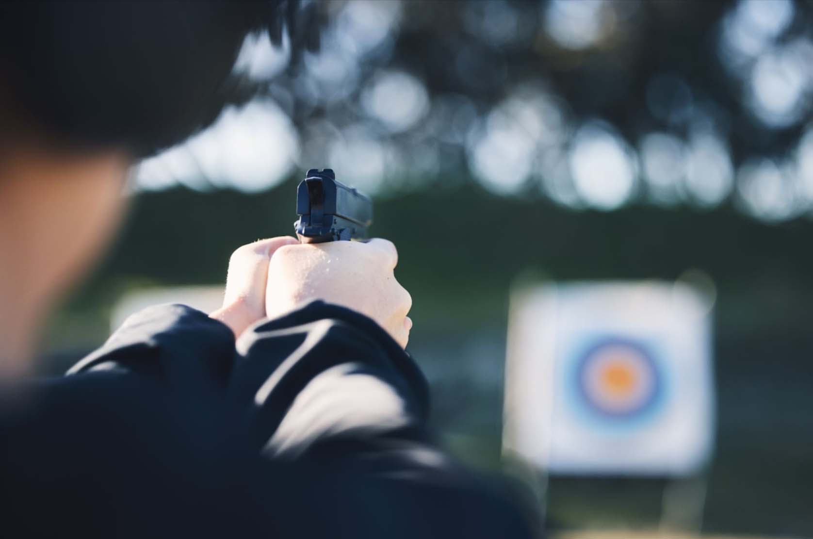 An outdoor shooting range where a shooter practices target shooting.