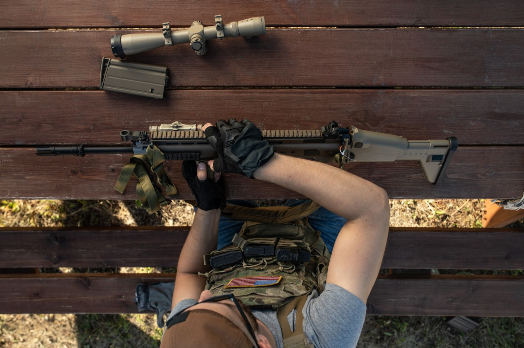 An unidentified man assembles his personally tailored long-range rifle for shooting.