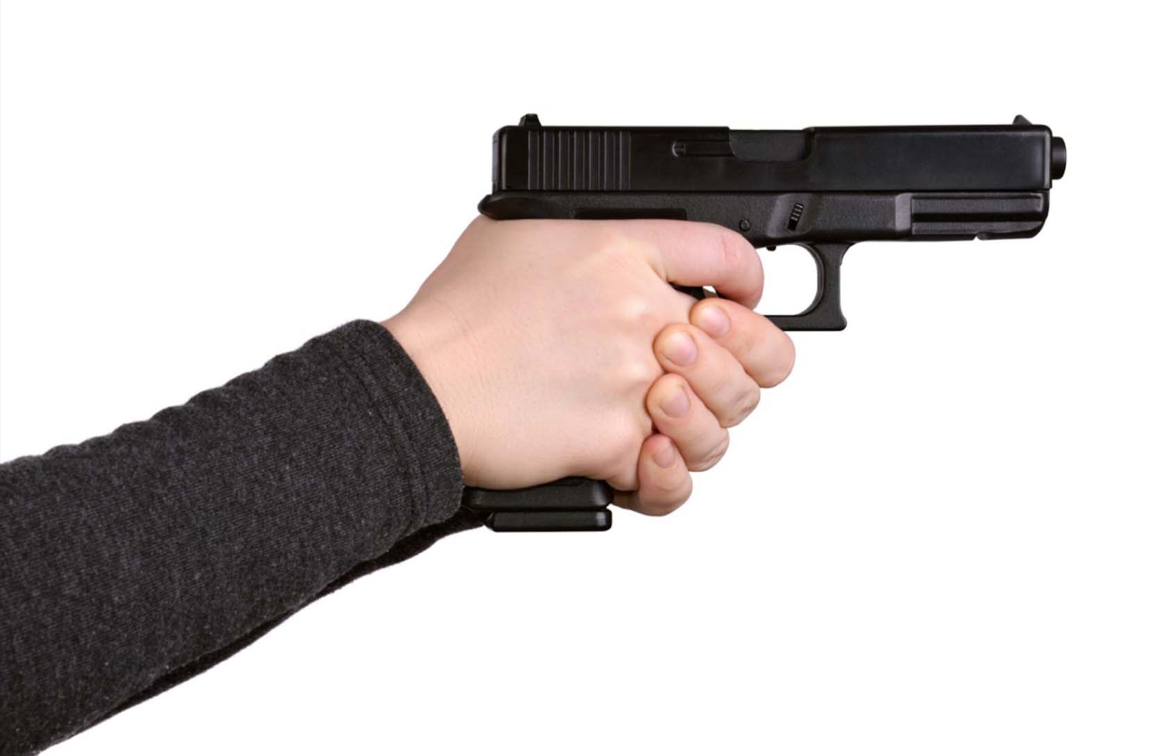 Detailed close-up of a hand gripping a pistol, showcasing the firearm's design and the proper holding technique.