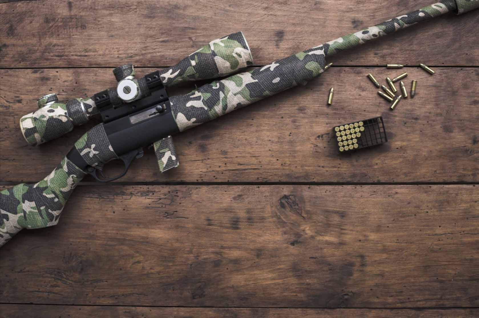 A small 22 caliber rifle with optical sight and camouflaged cartridges.